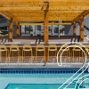 a pool with a bar and chairs behind it