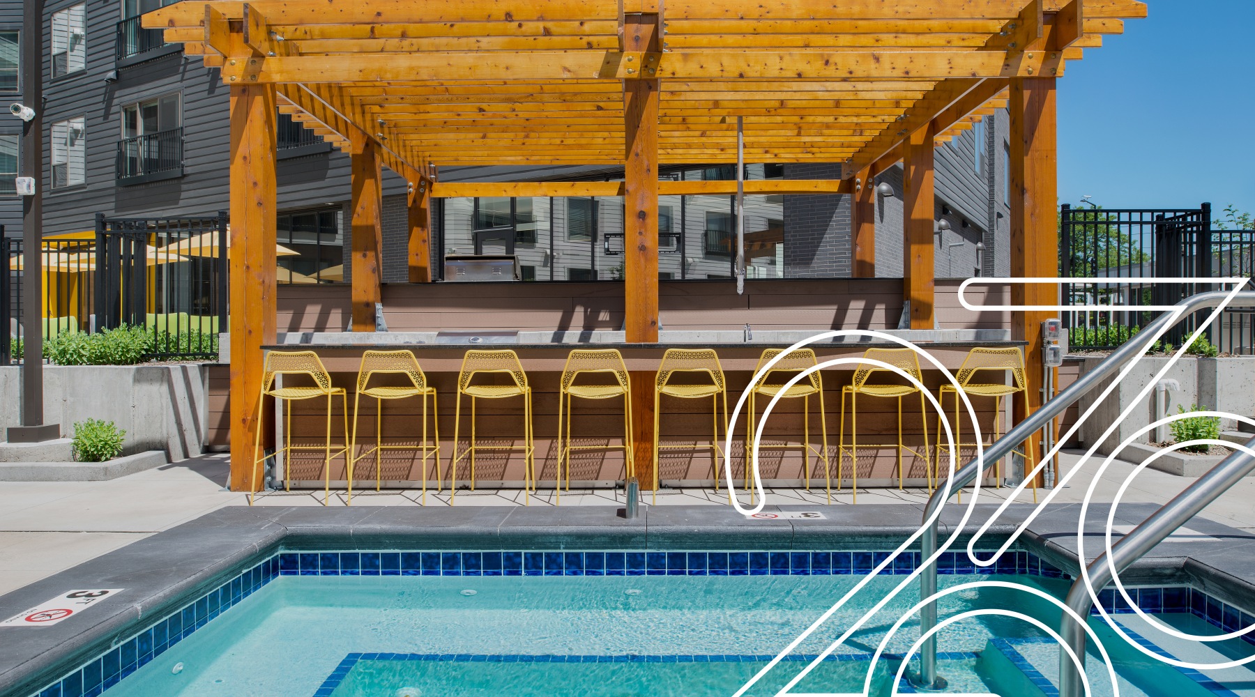 a pool with a bar and chairs behind it