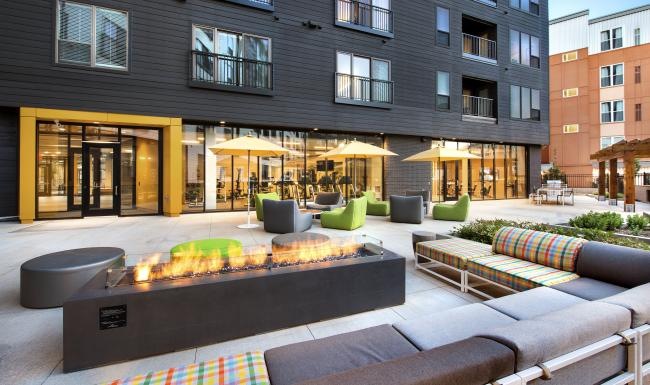 a patio with a firepit and chairs